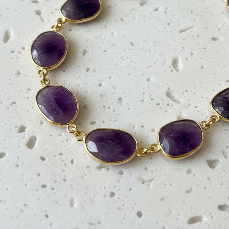 Close up of hand-set natural amethyst ovals on gold plated links, February birthstone necklace