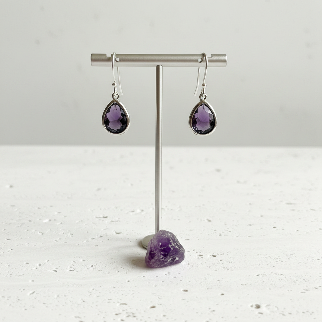 Amethyst purple faceted glass drop earrings in silver plated brass, shown hanging