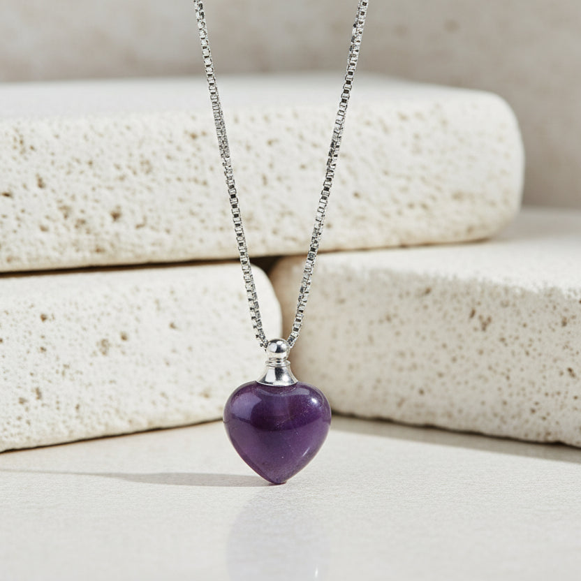Purple heart-shaped pendant on a silver chain against a white background