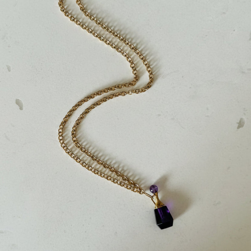 Full view of amethyst crystal vial keepsake necklace on 68 cm gold plated chain, February birthstone