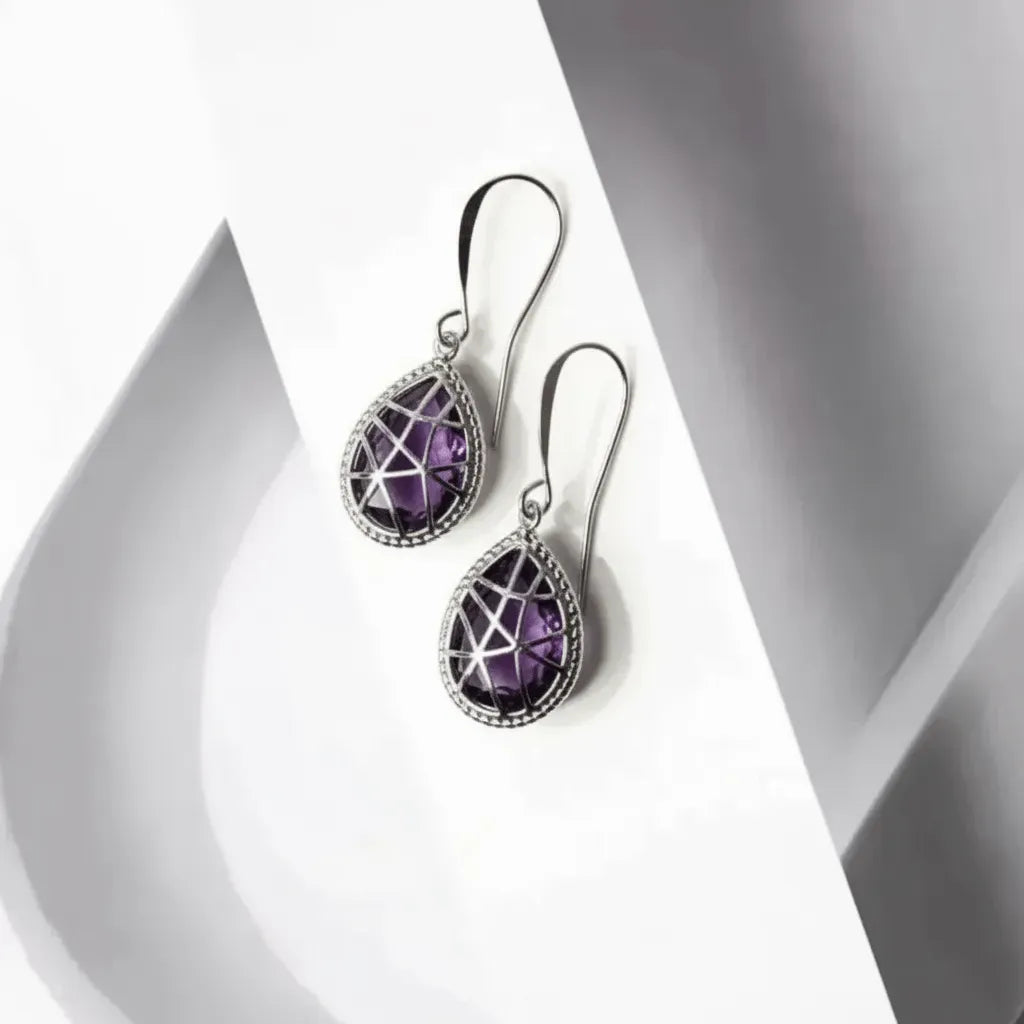 Pair of purple teardrop earrings on a white background