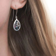 Woman wearing amethyst web drop earring in silver, February birthstone jewelry