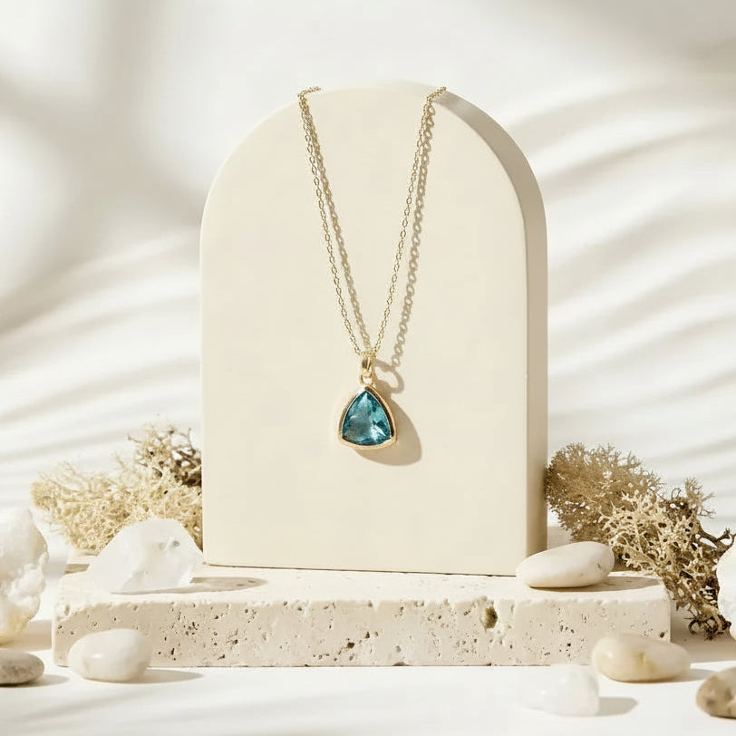 Aqua blue Athena pendant necklace in gold on stand, March birthstone jewelry