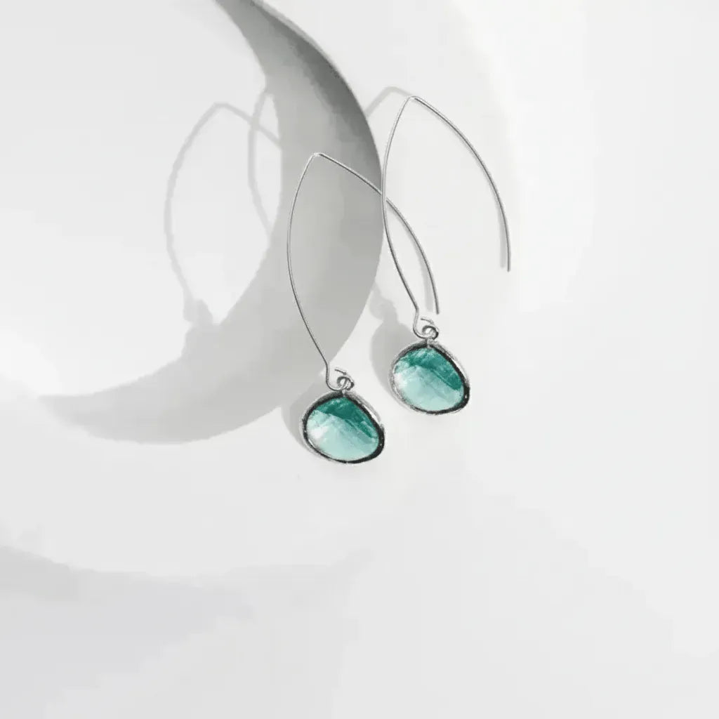 Teal earrings on a white background