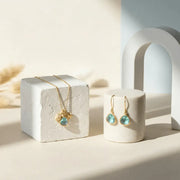 Gold jewelry with turquoise stones on a white surface