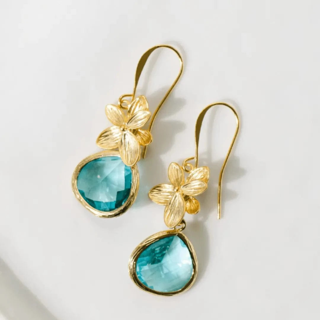 Gold earrings with turquoise stones on a light background