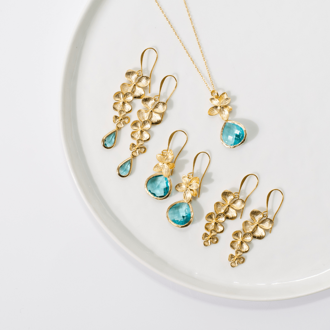 Gold and turquoise jewelry set on a white plate