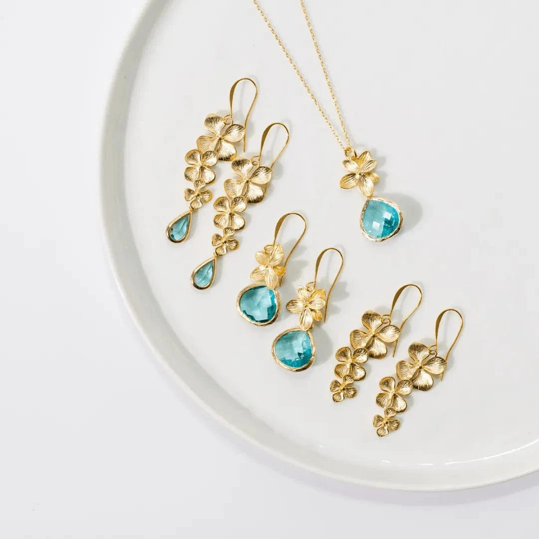 Gold and turquoise jewelry set on a white plate