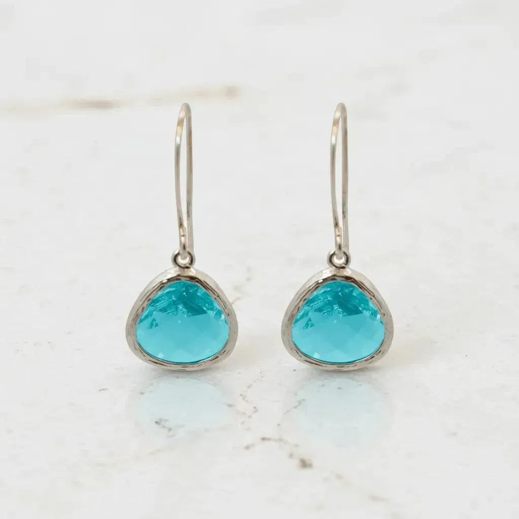 Turquoise teardrop earrings on a marble surface