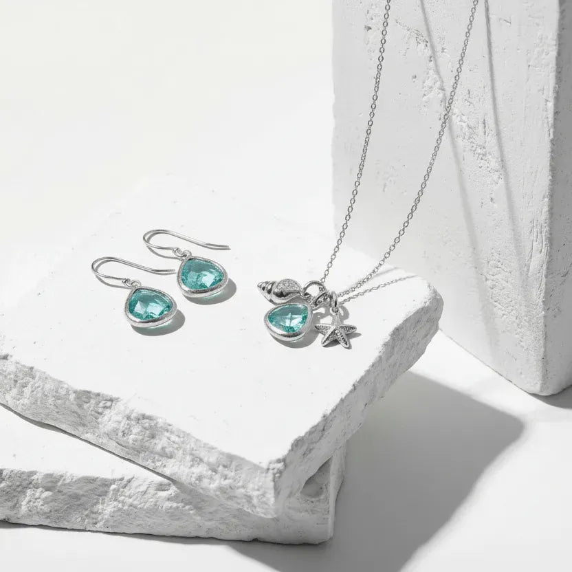 Jewelry set with turquoise stones on a white stone surface