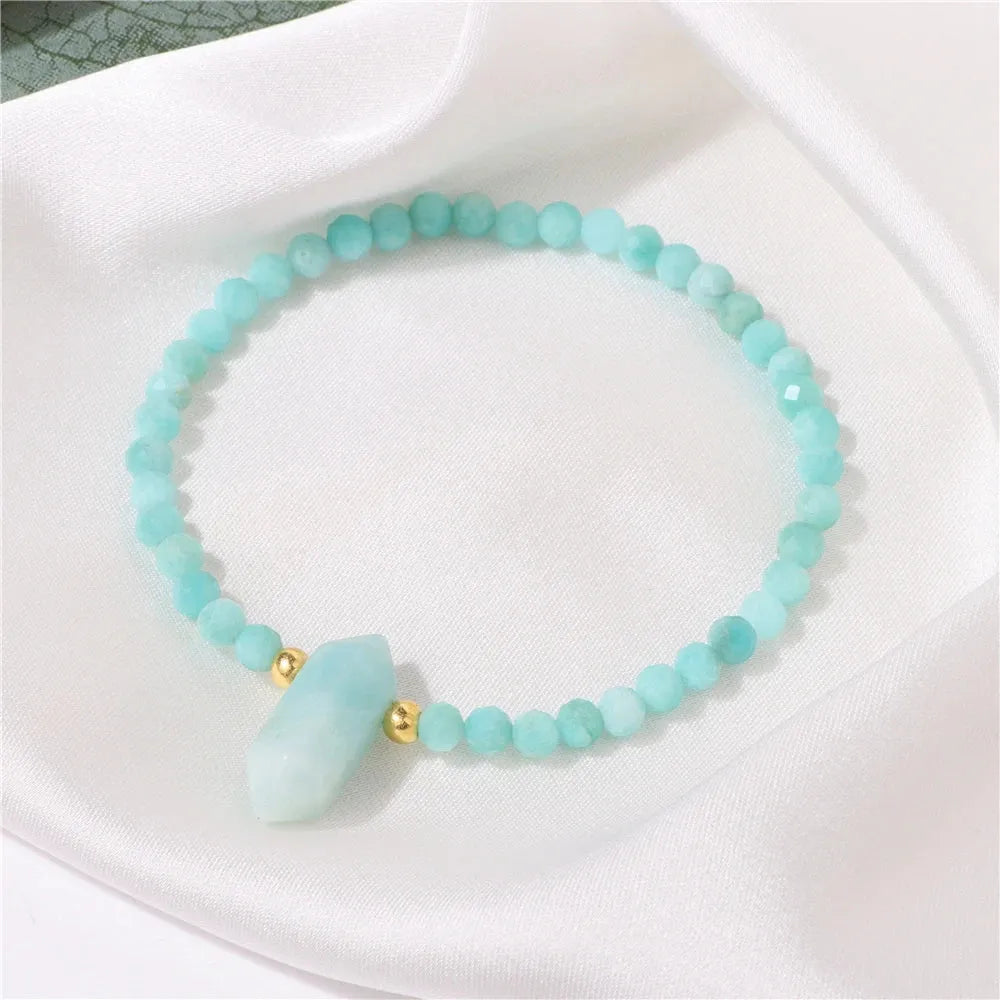 Turquoise beaded bracelet with gold accents on a white surface