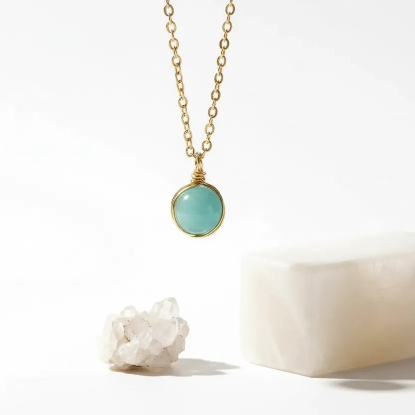 Gold necklace with a turquoise pendant on a white background