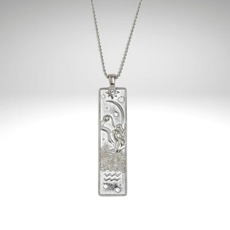 Silver pendant with chain on a light gray background