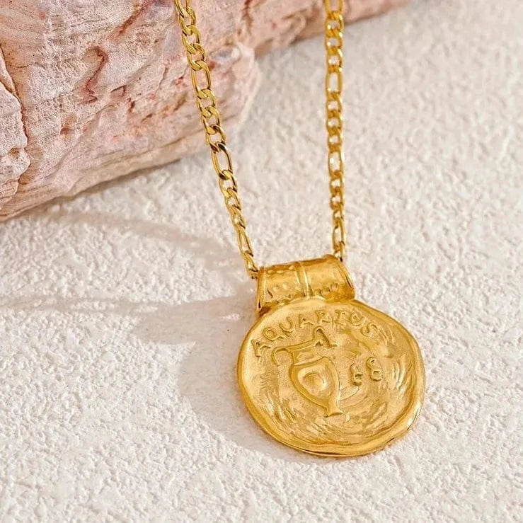 Gold necklace with a coin pendant on a textured surface