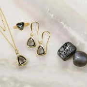 grey gold jewelry set with necklace earrings and ring in flat lay with crystals