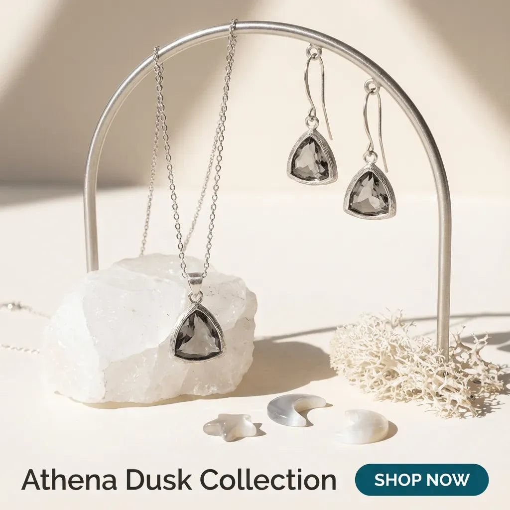Jewelry set with necklace and earrings on a stand with 'Athena Dusk Collection' text.