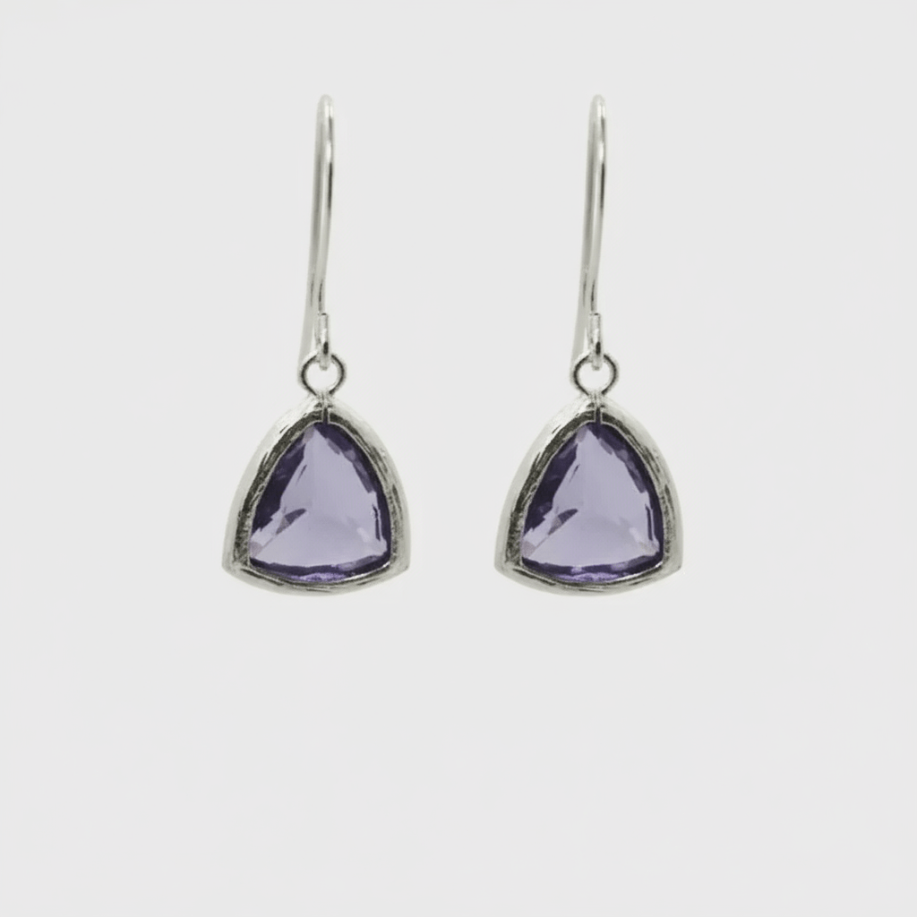Pair of silver earrings with purple gemstones on a white background