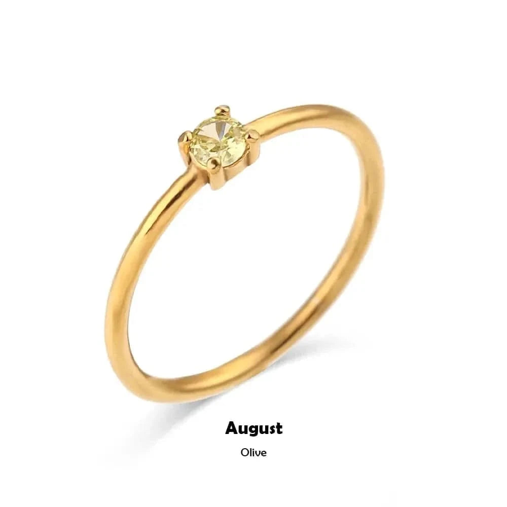 Gold ring with a yellow gemstone on a white background, labeled 'August Olive'.