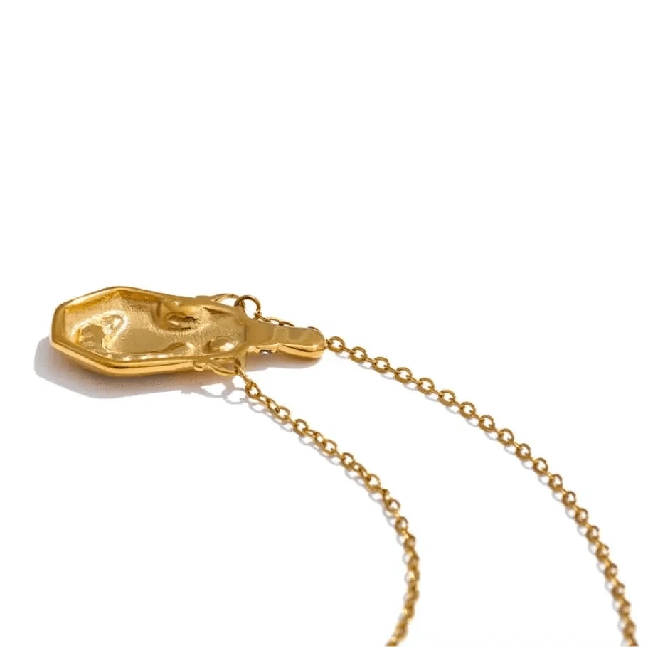Gold necklace with a unique pendant on a white background