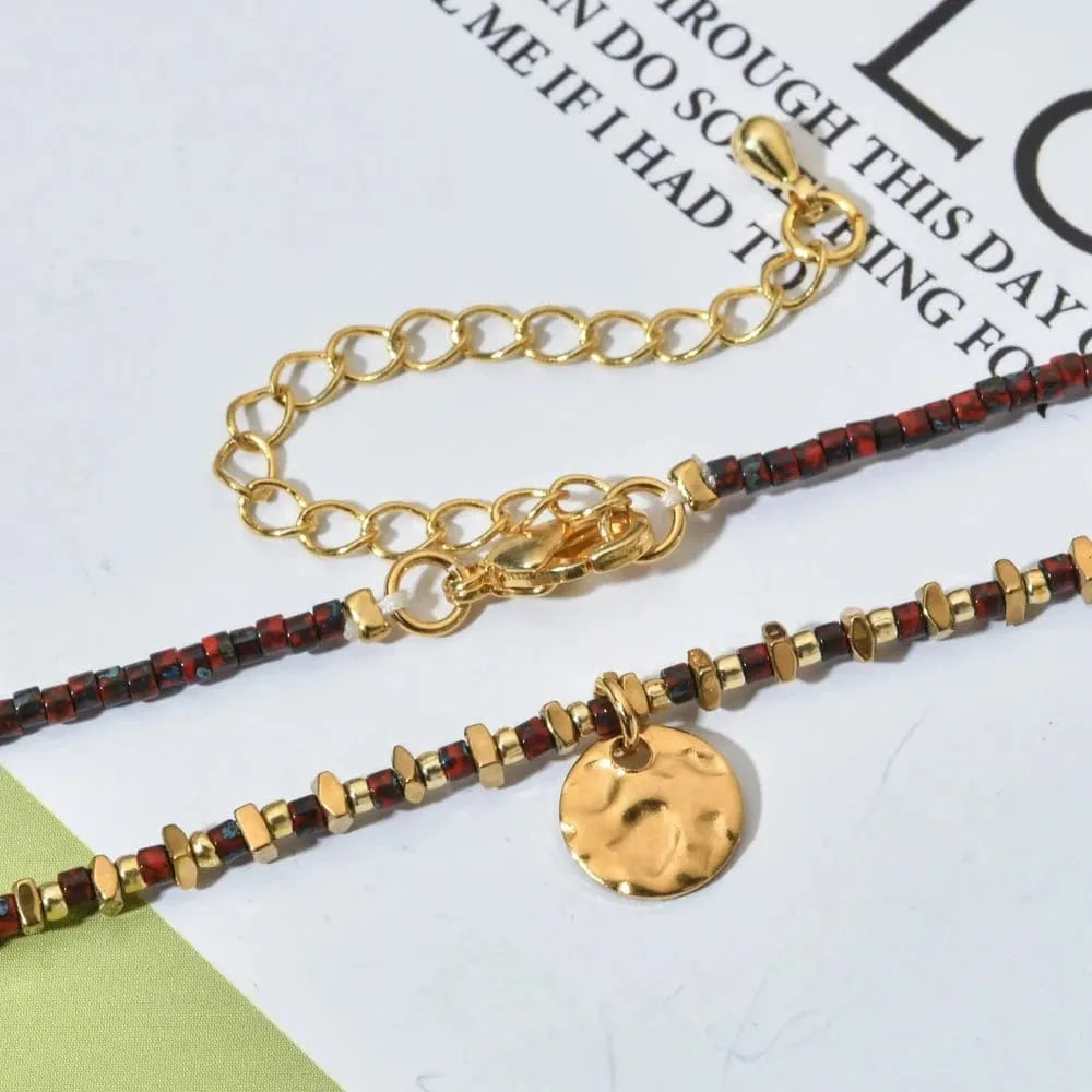 Gold and red beaded bracelets on a magazine page