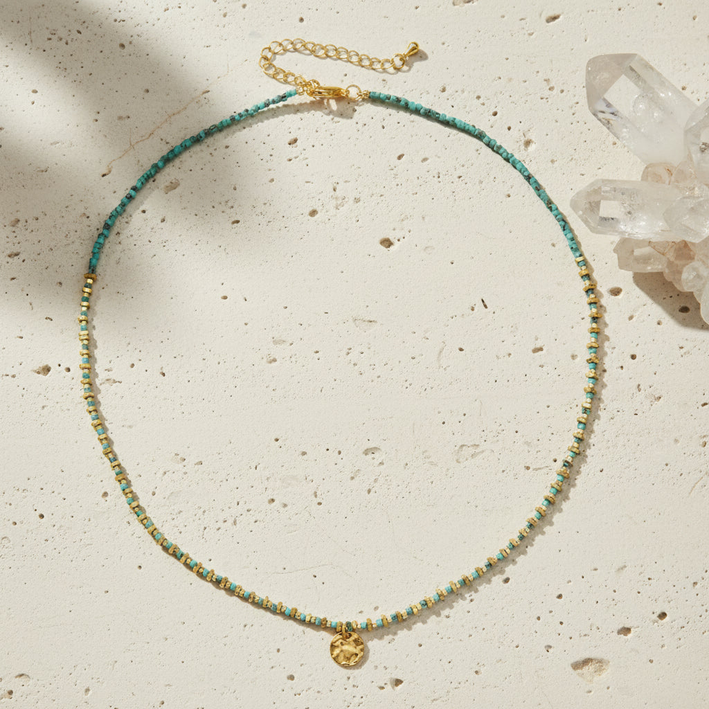 Necklace with green and gold beads on a white background
