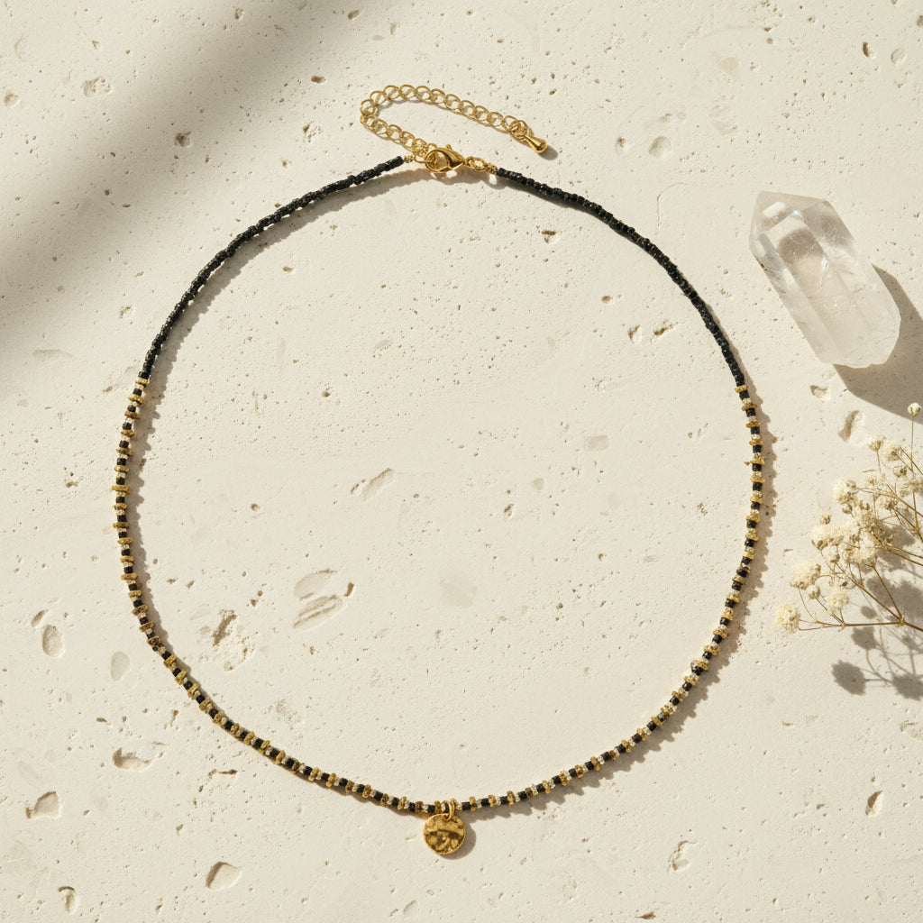 Necklace with black and gold beads on a white background