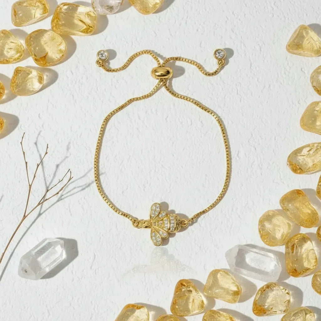 Gold bracelet with a star-shaped clasp on a white background with pink stones.