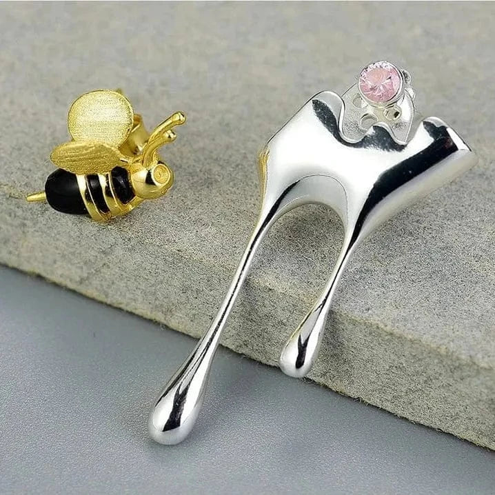 Silver and gold earrings on a textured surface