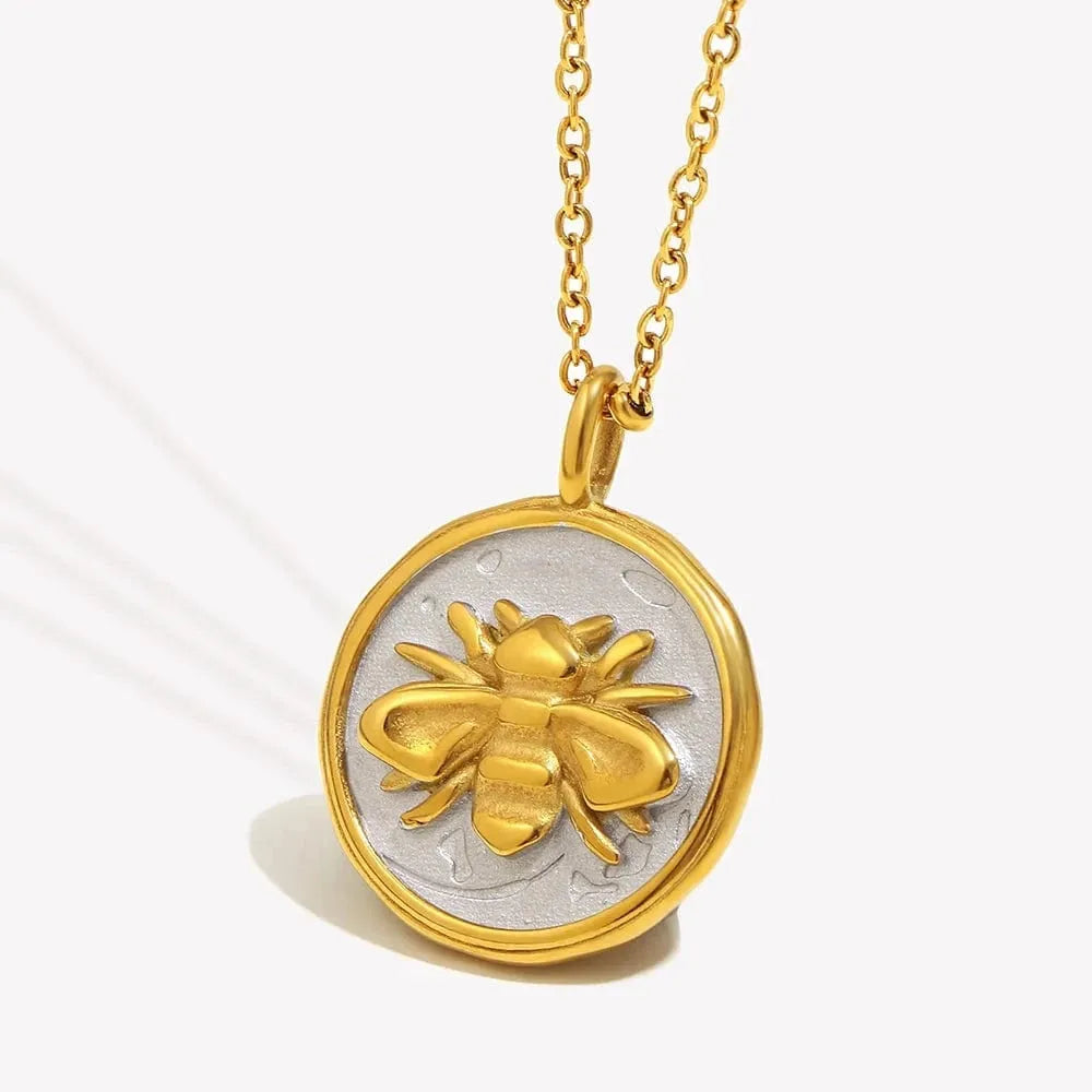 Gold and silver bee pendant necklace on a white background