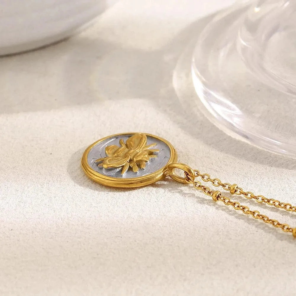 Gold necklace with a butterfly pendant on a light background