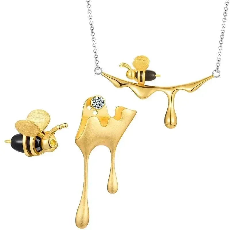 Gold necklace with bee design on a white background