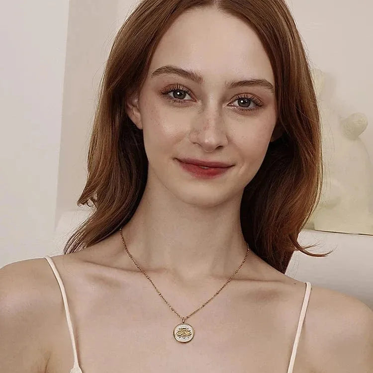 Woman wearing a delicate necklace with a neutral background