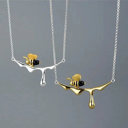 Bee and Dripping Honey Pendant Necklace on a gray background