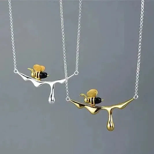 Bee and Dripping Honey Pendant Necklace on a gray background