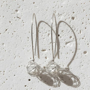 silver earrings on a white flat lay surface