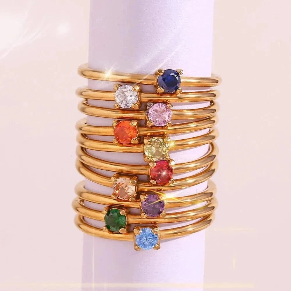 Gold bangles with colorful gemstones on a white background