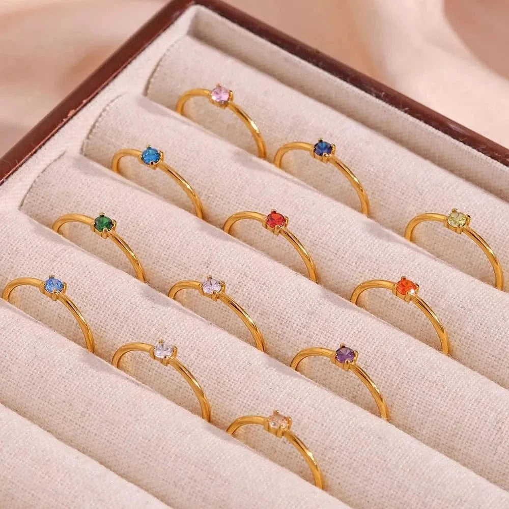Set of gold rings with colorful gemstones in a jewelry box