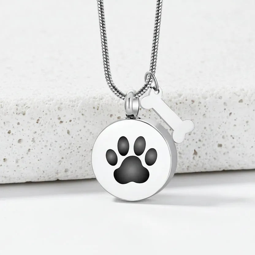 Necklace with a round pendant featuring a black paw print on a white background