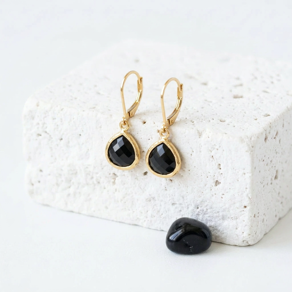 Gold Petite Pebble leverback earrings in black faceted glass