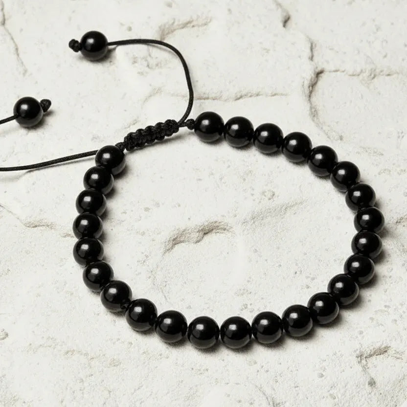 Black beaded bracelet on a light marble background