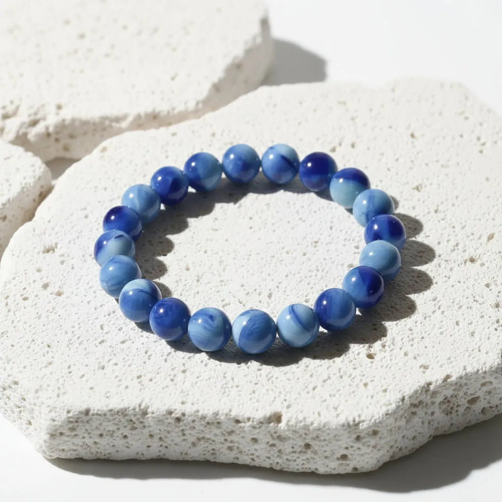 Blue beaded bracelet on a white stone surface