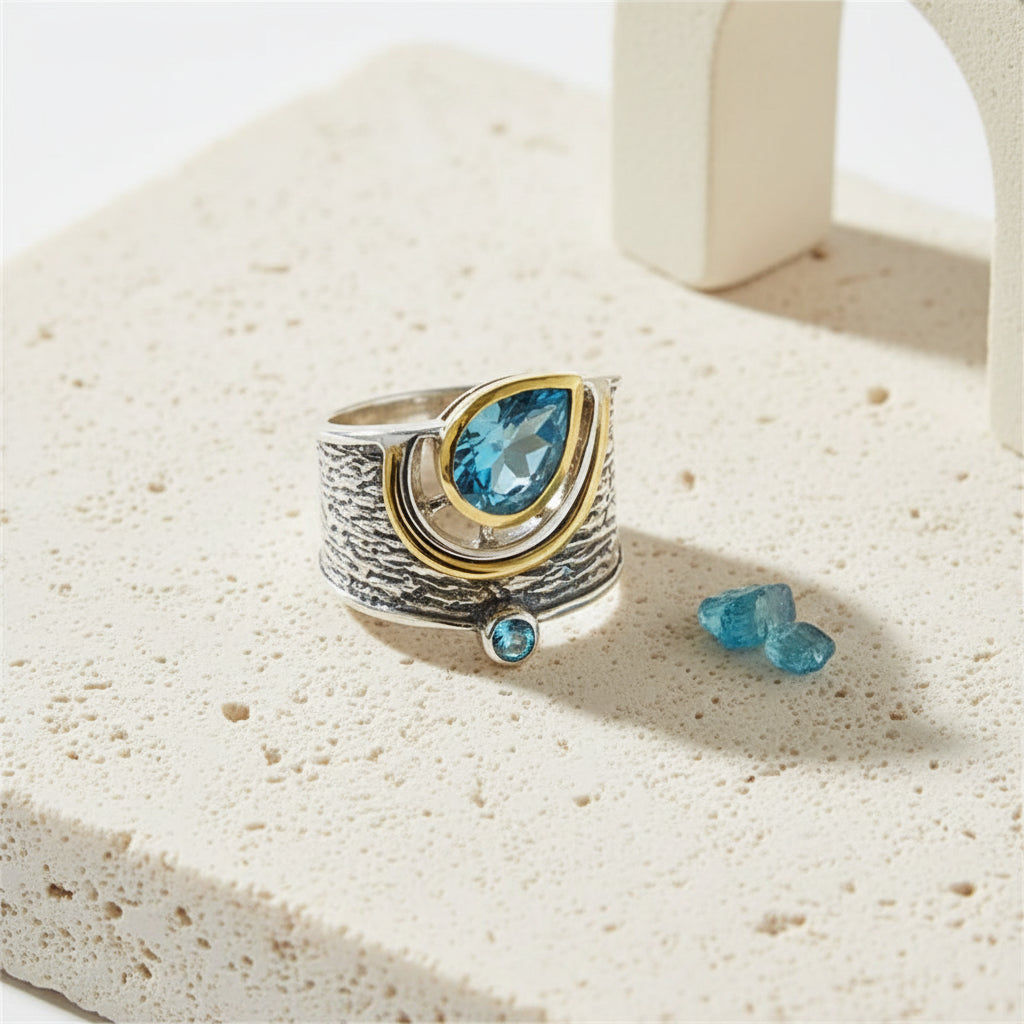 Blue pear-cut statement ring in two-tone silver and gold with a bark-textured band