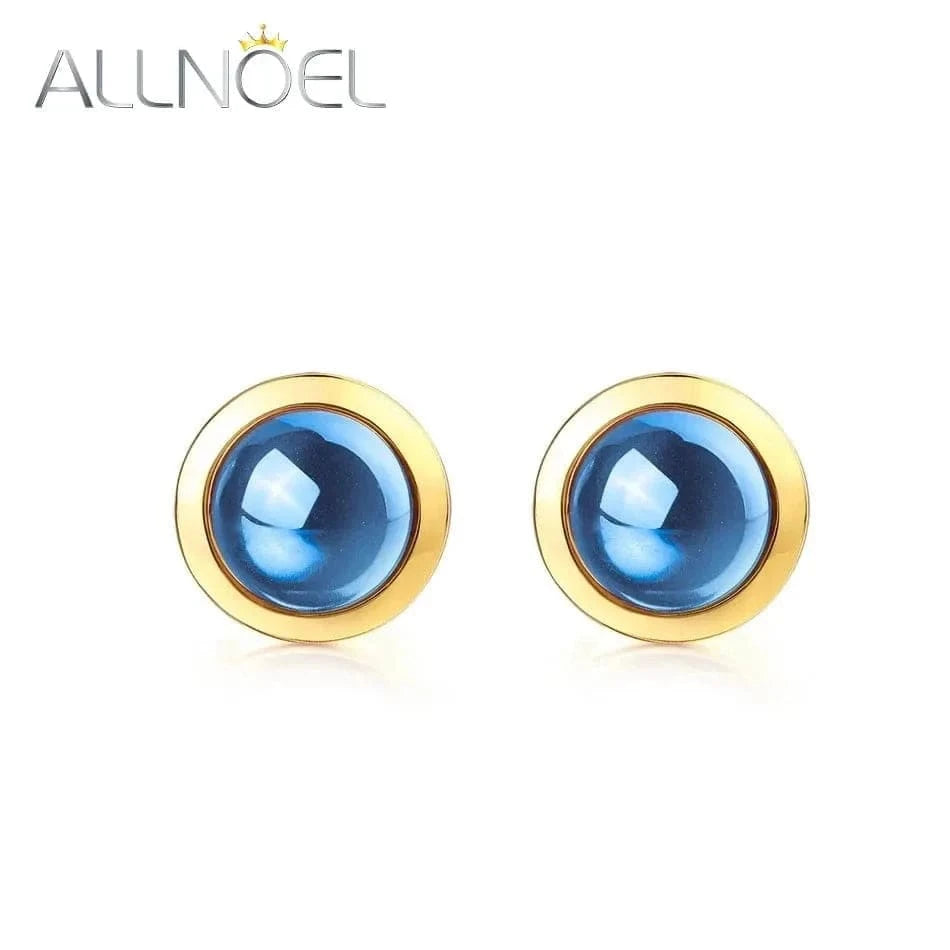 Gold earrings with blue gemstones on a white background