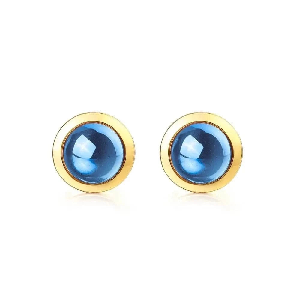 Gold earrings with blue gemstones on a white background