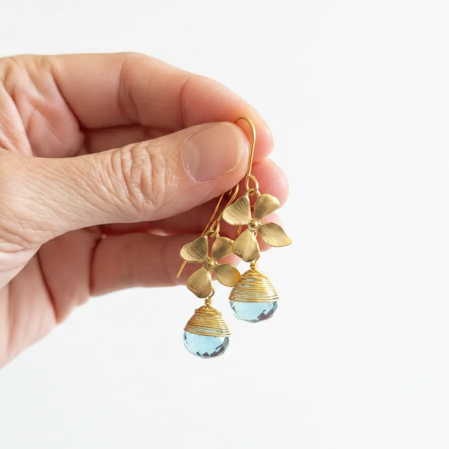 gold blue topaz orchid drop earrings held in hand — one-of-a-kind crystal jewelry for calm
