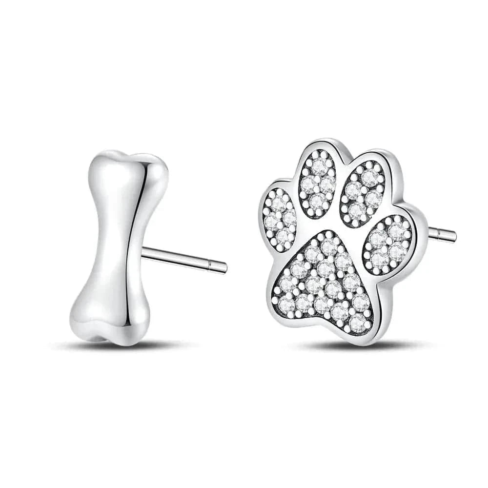 Silver paw print and bone-shaped earrings on a white background