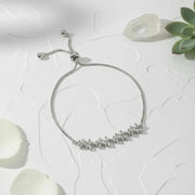Silver bracelet with small stones on a white surface with decorative elements