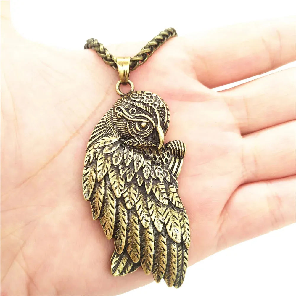 Bronze owl wing pendant on a hand