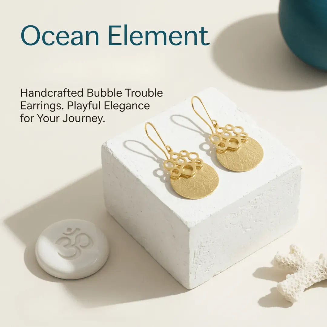 Gold earrings on a white block with 'Ocean Element' text and branding.