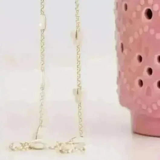 Gold necklace with a pink ceramic holder on a white background